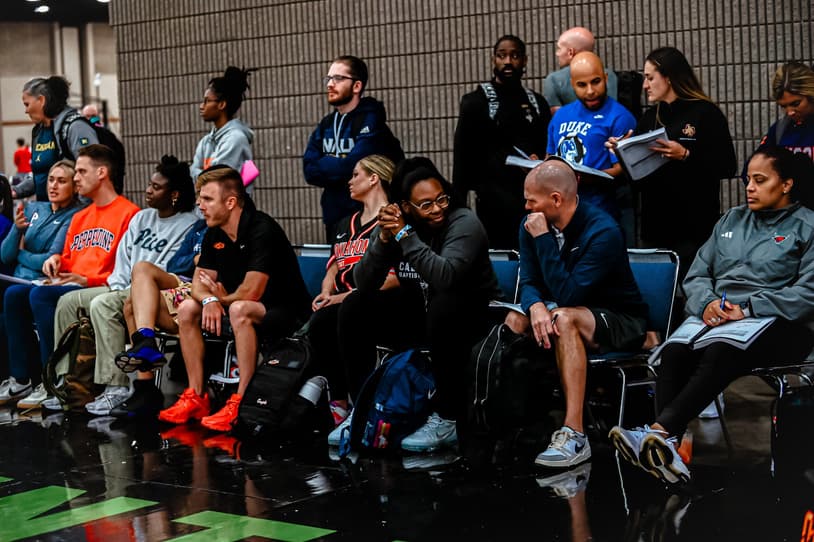 College coaches watching from the sideline at a girls AAU tournament
