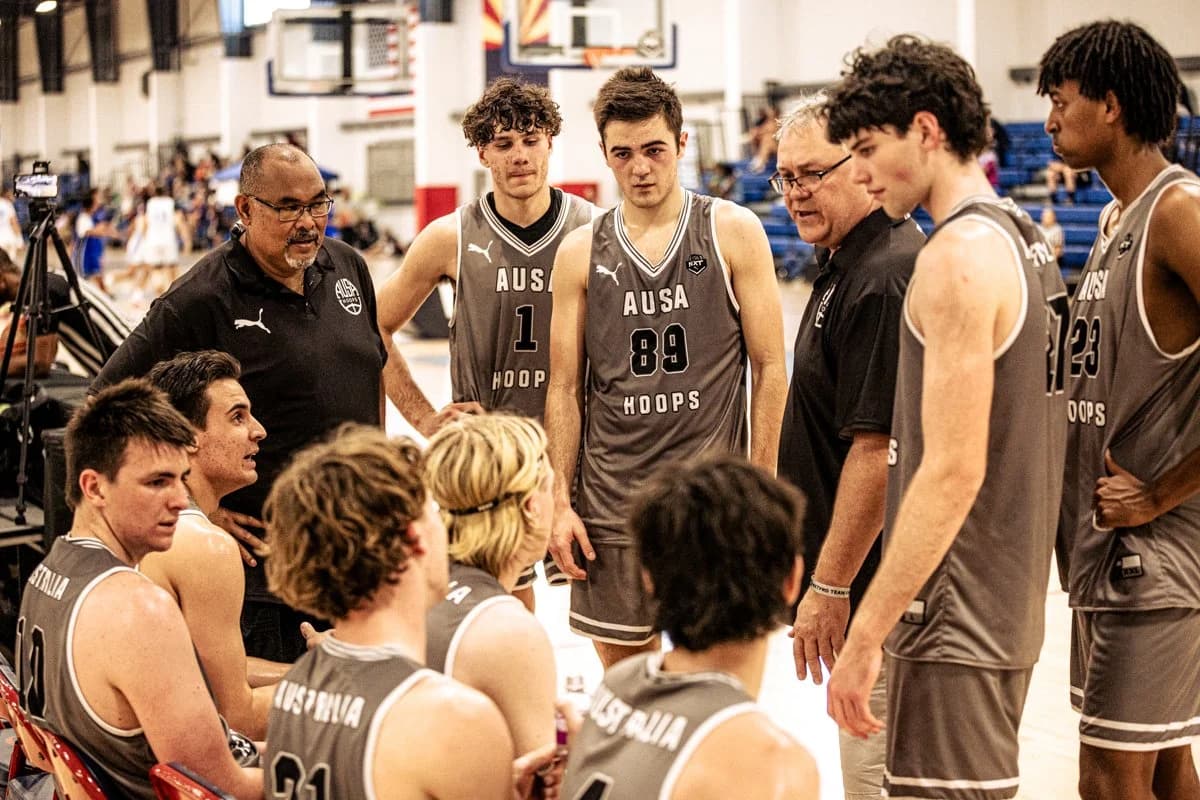 An AUSA Hoops coach addressing his team in a huddle at a US AAU tournament