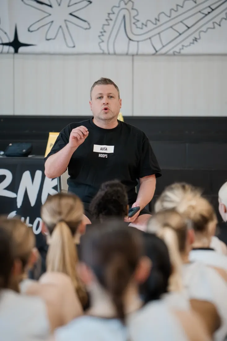 An AUSA Hoops staff member briefing a squad before a session
